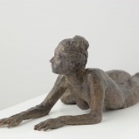Female sculpture lying on her front side, whilst bent towards an angles, as seen in a AK Asimis Kolaitou art gallery in Santorini, Greece.