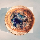 Clay bowl with intricately painted streaks using different shades of blue crystal in the interior of the bowl representing land and water, by contemporary Greek artist Eleni Kolaitou
